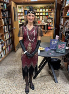 Woman in costume standing in front of books