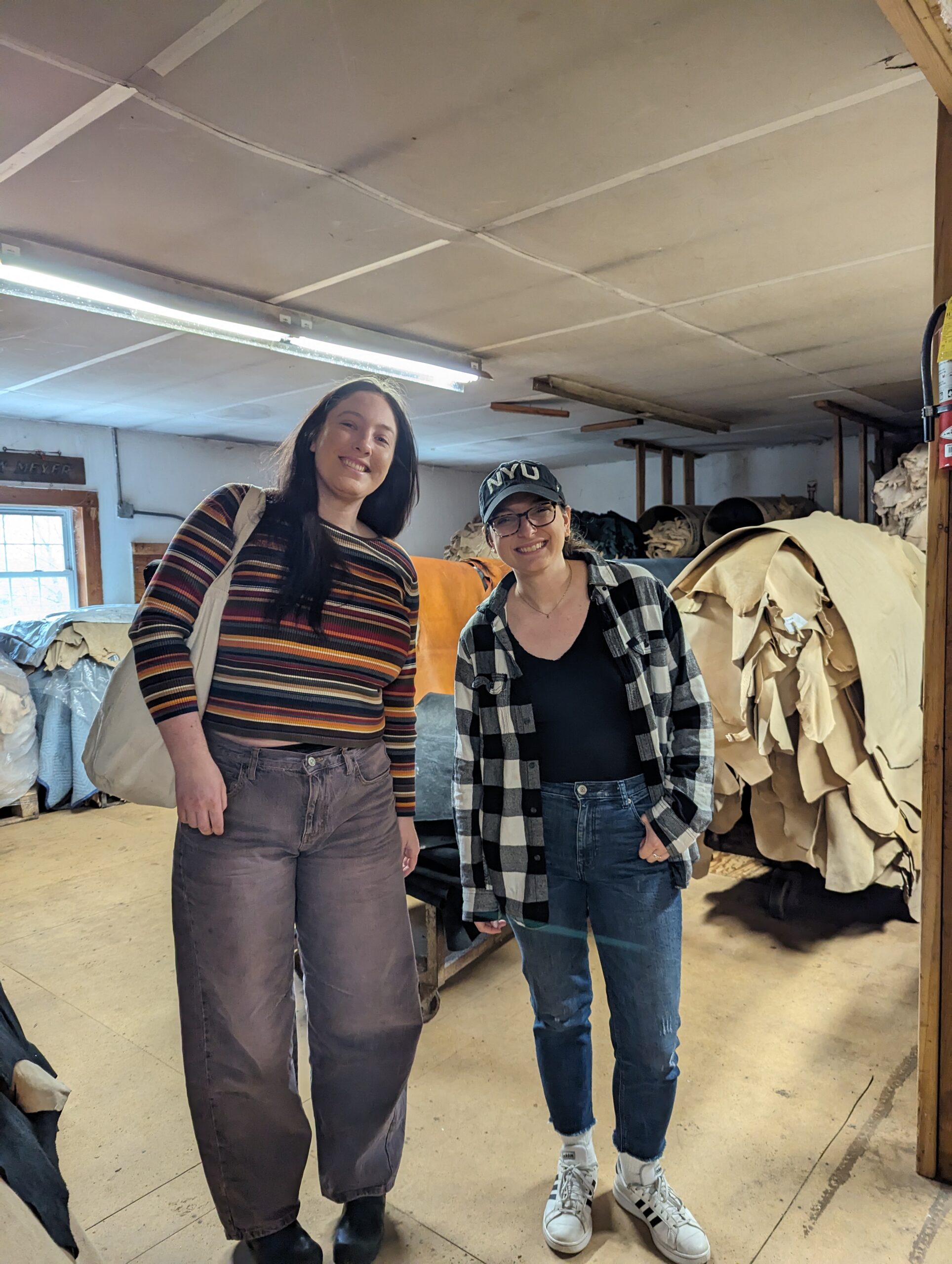 Two graduate students posed in front of Pergamena's leather stock.