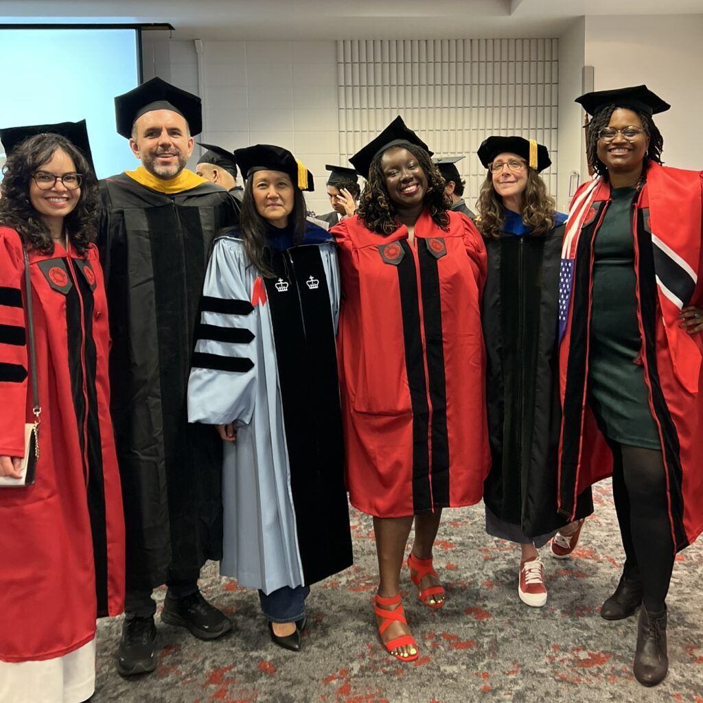 Group photo of Drs. Thayane Bretas, Sean Mitchell, Jamie Lew, Tolu Lanrewaju-Kadri, Mara Sidney, and Nakeefa Bernard. They all stand in PhD Regalia.