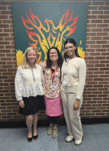 Teachers from Jersey City Infinity Institute in front of a mural in their school.