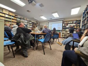 A group of people sitting in a room watching a presentation