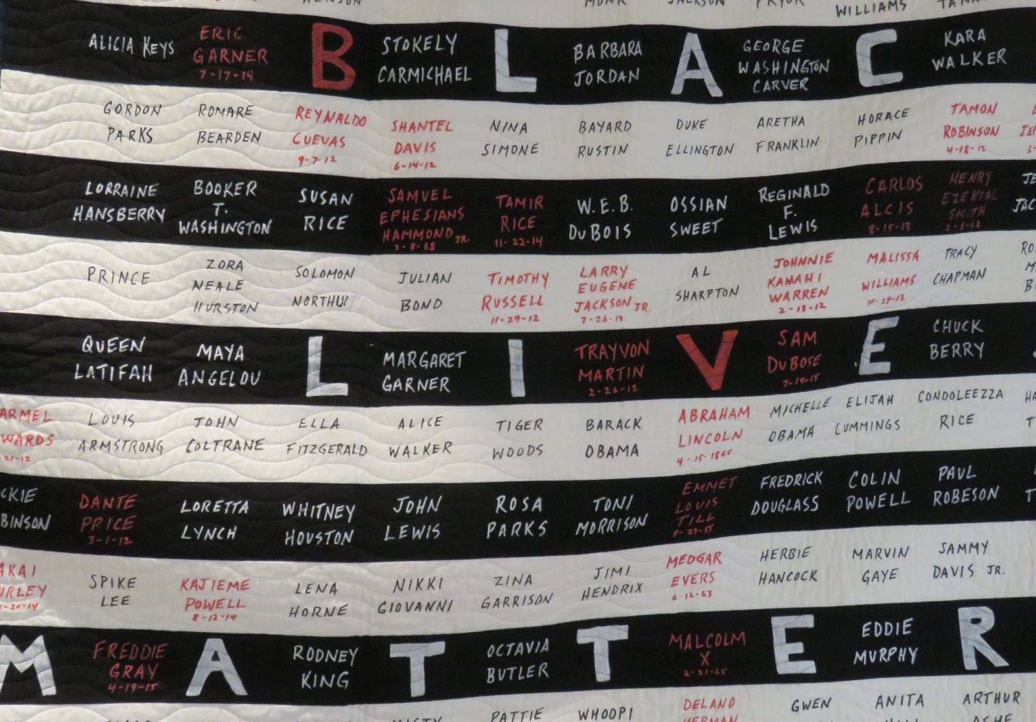 Black Lives Matter banner with black and white stripes and names.