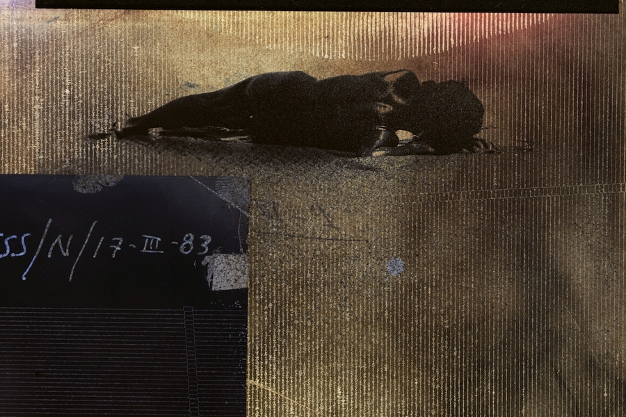 Child laying on side with brown background, white seismic register lines and black box in corner with abbreviations and text.