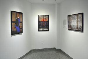 Installation view of three photographs with black frames, figure, heart, and seismic register lines.