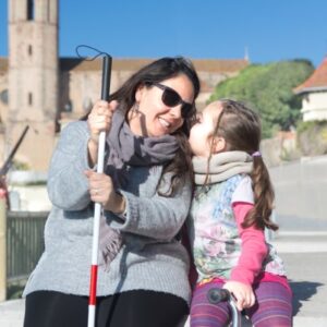 A child and blind woman sit together on a bench.