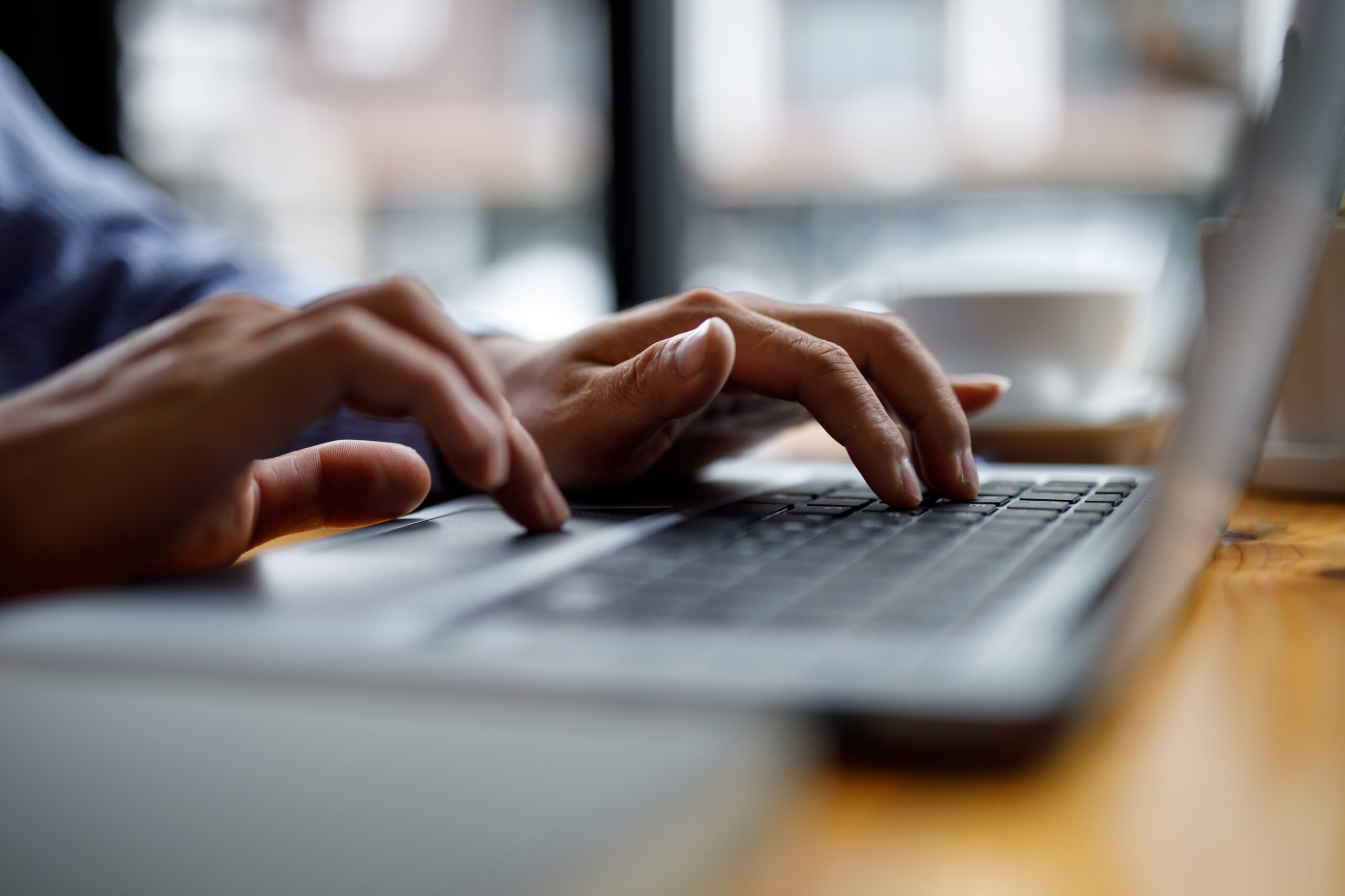 Close up of hands typing on computer keyboard.