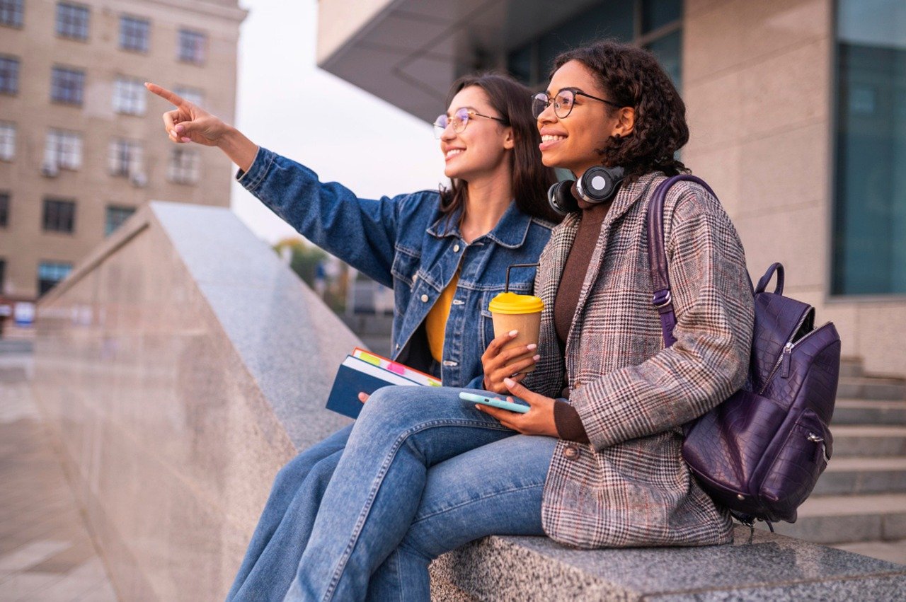 Two students sitting with one pointing