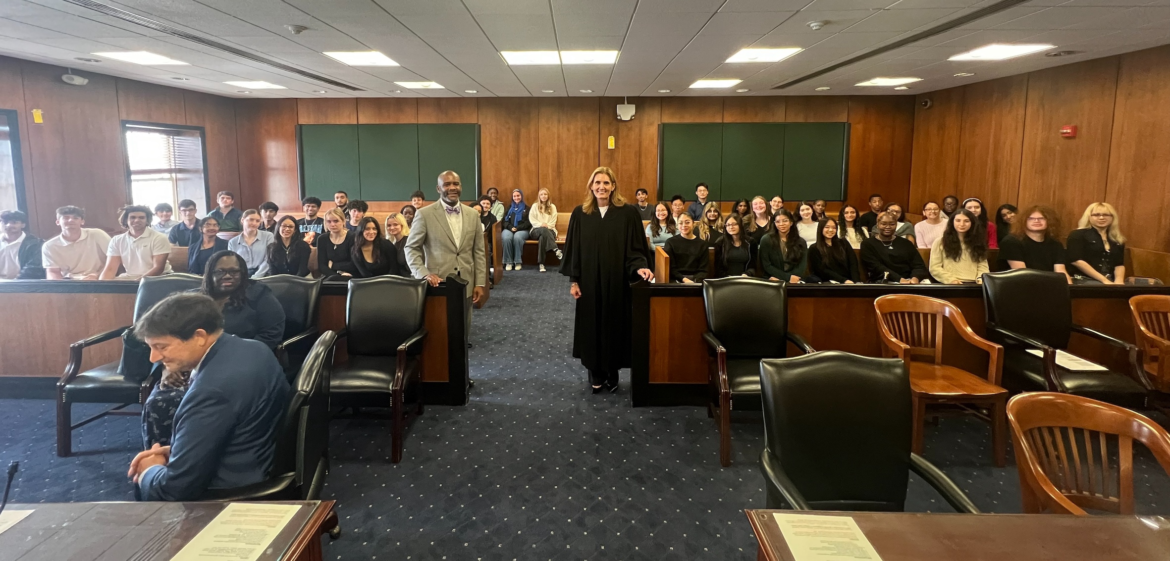 Students sitting in courthouse with court officials.