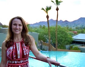 Kristen Syrett in front of sunset and pool in Scottsdale, Arizona