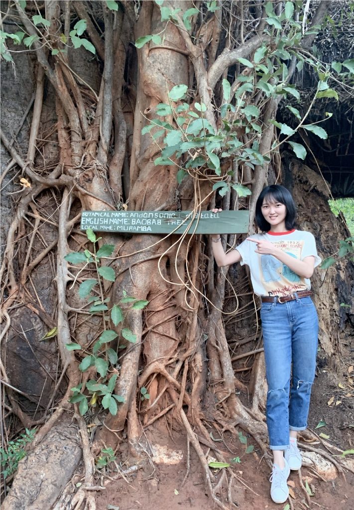 Meng Zhang next to a tree