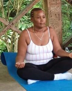 Person meditating outside with plants