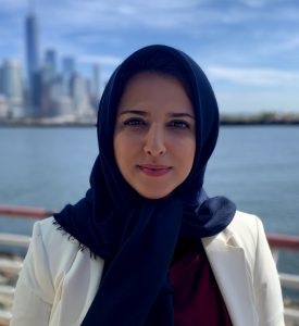Headshot of Sajedeh Goudarzi with water and cityscape in background.