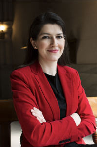 Headshot of Dr. Amzi-Erdogdular in a red blazer.