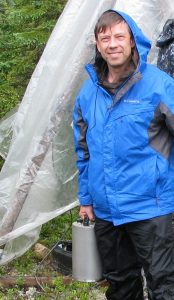 Vadim retrieves a sensor from wet forest